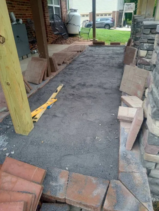 Patio base being prepared for pavers under a deck